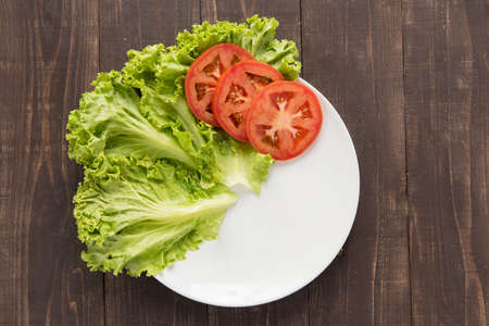 empty plate with tomatoes and vegetable waiting for foodの写真素材