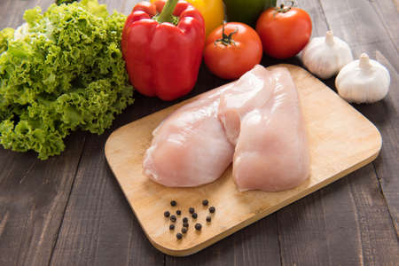 Raw chicken breast fillets and vegetable on wooden backgroundの写真素材