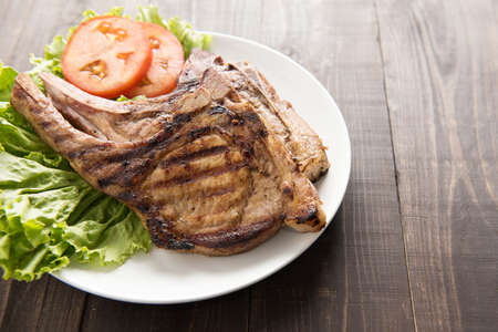 Grilled steak with vegetables on a wooden backgroundの写真素材