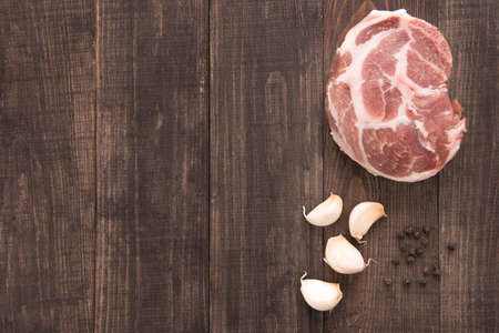 Top view raw fresh meat and garlic, pepper on wooden background.の写真素材