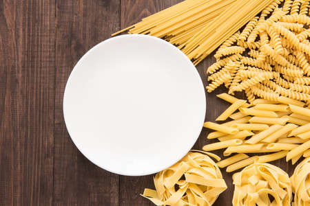 Mixed dried pasta selection on wooden background, copy space, top viewの写真素材