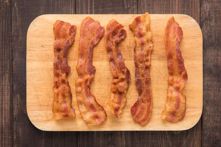 Fried bacon strips on the wooden board.の写真素材