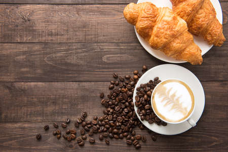 Coffee cup and fresh baked croissants on wooden background. Top View.の写真素材