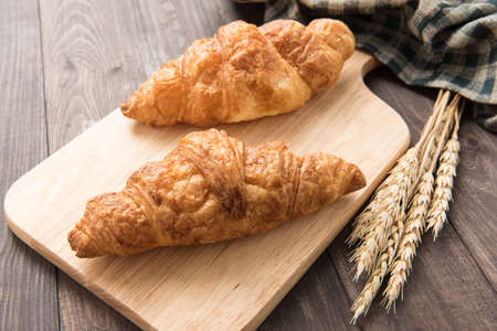 Freshly baked butter croissant on wooden backgroundの写真素材