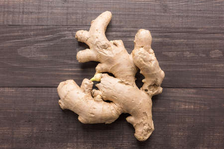 Ginger root on the wooden background. Top view.の写真素材