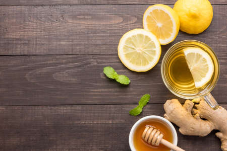 Cup of ginger tea with lemon and honey on wooden background.の写真素材