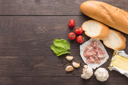Ingredients for sandwich with smoked meat, baguette on wooden background.の写真素材