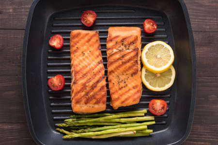 Grilled salmon cooked BBQ on a pan on wooden background.の写真素材