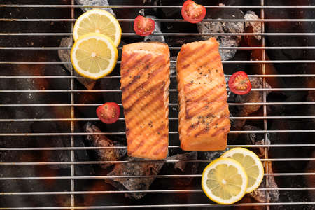 Grilled salmon with lemon on the flaming.の写真素材
