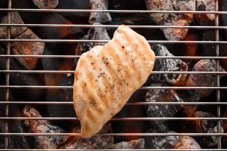 Grilled chicken breast on the flaming grill.の写真素材