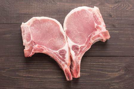 Top view raw pork chop steak on wooden background.の写真素材