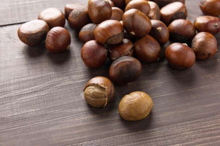 Delicious roasted chestnuts on the wooden background.の写真素材