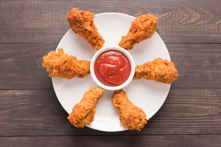 fried chicken drumstick and ketchup on wooden background.の写真素材