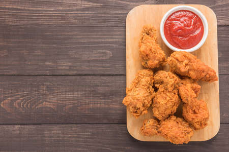 fried chicken drumstick and ketchup on wooden background.の写真素材