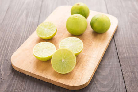 Fresh limes on cutting board on wooden table.の写真素材