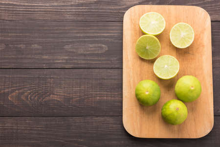 Fresh limes on cutting board on wooden background.の写真素材