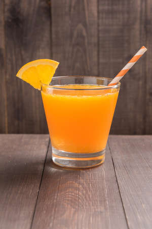 Glass of fresh orange juice on wooden table.の写真素材