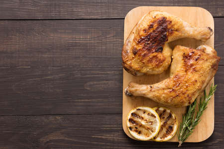 Grilled chicken lag and rosemary on wooden background.の写真素材