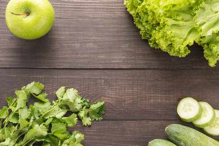 Green vegetables and green fruit on rustic wood table.の写真素材