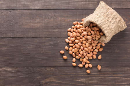 Peanut in sacks on the wooden background.の写真素材