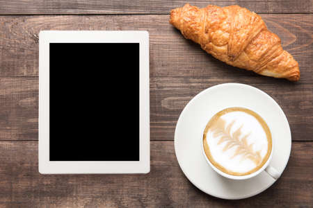 Coffee cup and fresh baked croissants on wooden background. Top View.の写真素材