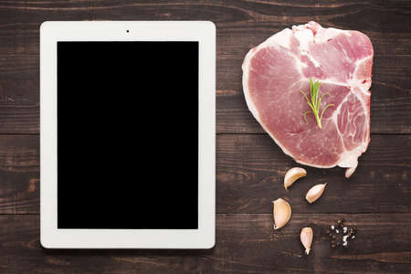 Top view raw pork chop steak and garlic, pepper on wooden background.の写真素材
