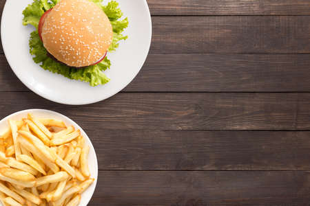 Top view bbq hamburger and french fries on the wooden background.