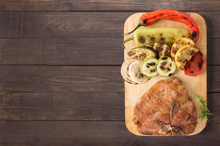 Grilled pork chop and vegetables on the wooden background. Copyspace for your text.の写真素材