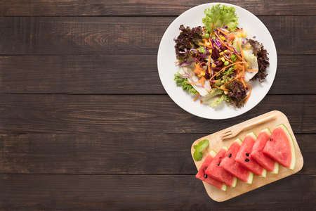 Fresh salad and watermelon on the wooden background. Top view.の写真素材