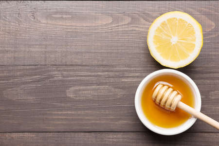 Bowl of sweet honey and lemons on wooden table.の写真素材