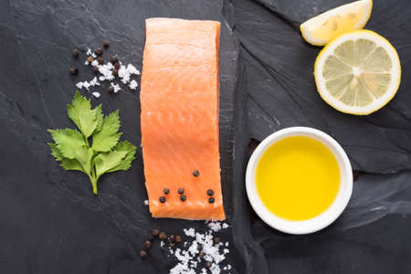 Fresh salmon with lemon on black background.の写真素材