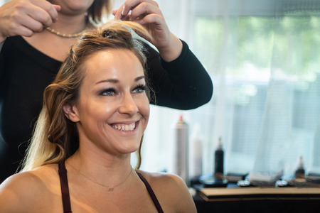 Young Beautiful Smiling Woman Getting Hair Curledの写真素材