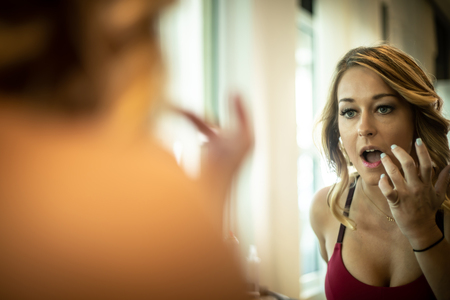 Gorgeous Woman Applying Lipstick In The Mirror At The Spaの写真素材