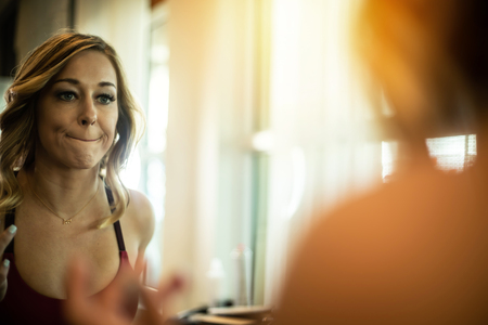 Beautiful Woman Applying Lipstick In The Mirror At The Salonの写真素材