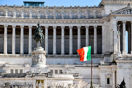 Front view of the monumental complex of the Vittoriano in the center of Rome, also known as "Altare della Patria". A large Italian national flag is wavingのeditorial素材