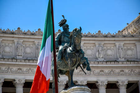 A large Italian national flag next to the equestrian statue of King Vittorio Emanuele II in the center of Romeのeditorial素材