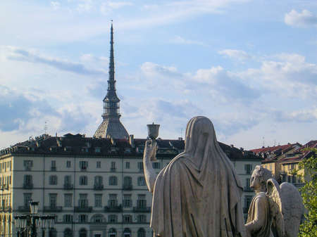Back of a statue raising a cup and observing the dome of the Mole Antoneliana in Turin.のeditorial素材