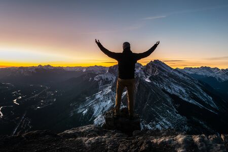 Man posing on top of the mountain during the sunrise. EEOR, Canmore, Canadaの写真素材