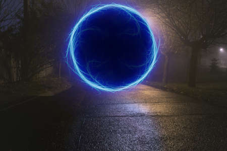 Dark alley with blue portal at misty cold nightの写真素材