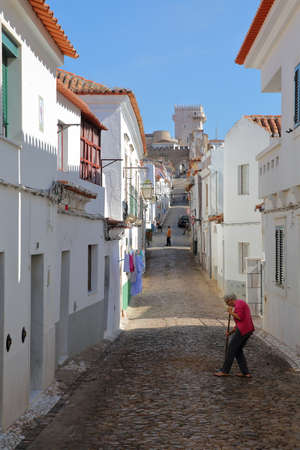 ESTREMOZ, PORTUGAL - OCTOBER 10, 2016: A typical cobbled street with the Tower of the Three Crowns (Torre das Tres Coroas)  in the backgroundのeditorial素材