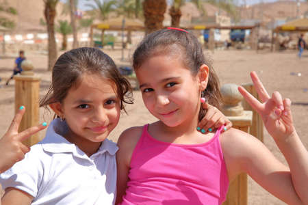 AQABA, JORDAN - MARCH 15, 2016: Portrait of two cute little girls smiling on a beachのeditorial素材