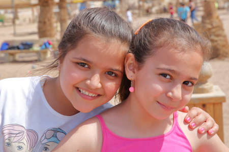 AQABA, JORDAN - MARCH 15, 2016: Portrait of two cute little girls smiling on a beachのeditorial素材