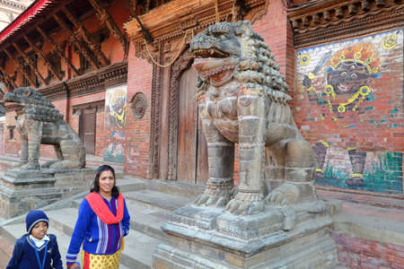 PATAN, NEPAL - DECEMBER 22, 2014: Nepalese woman and her son walking along Mul Chowk Royal Palace at Durbar Squareのeditorial素材