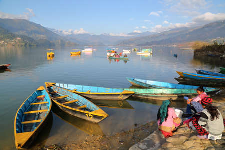 POKHARA, NEPAL - JANUARY 5, 2015: Nepalese women washing clothes along the shore of Phewa Lake, Pokhara, Nepalのeditorial素材