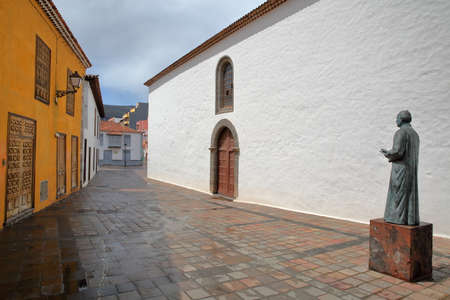 SAN SEBASTIAN DE LA GOMERA, LA GOMERA, SPAIN - MARCH 18, 2017: The statue of Father Jose Torres Padilla with a colorful facade on the left side and the Church of the Assumption on the right sideのeditorial素材