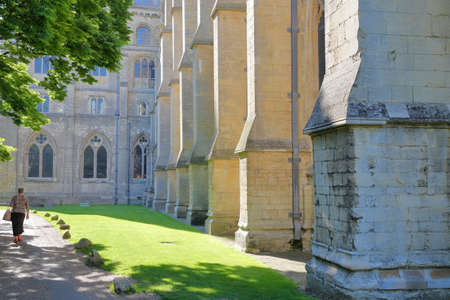 ELY, UK - MAY 26, 2017: View of the south part of the Cathedral on a sunny day with an elderly woman walking on the left sideのeditorial素材