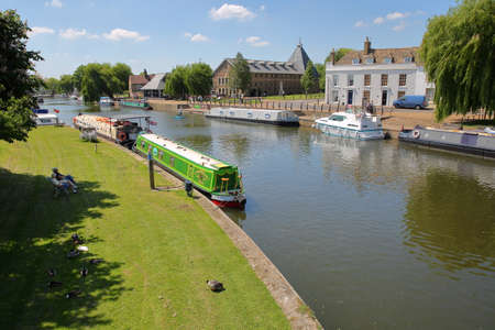 ELY, UK - MAY 26, 2017: The riverside in Spring with moored barges on the Great Ouse river and traditional housesのeditorial素材