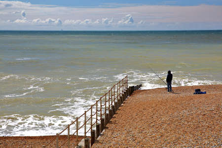 HASTINGS, UK - JULY 23, 2017: A fisherman on the beach of Hastings with a blue sky with nice cloudsのeditorial素材