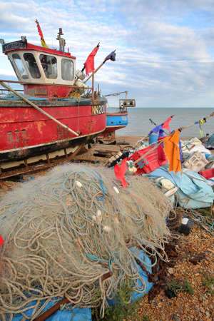 HASTINGS, UK - JULY 21, 2017: Beach launched fishing boats with colorful fishing nets in the foregroundのeditorial素材