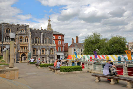 NORWICH, UK - JUNE 4, 2017: People relaxing at Memorial Gardens overlooking colorful market stalls...